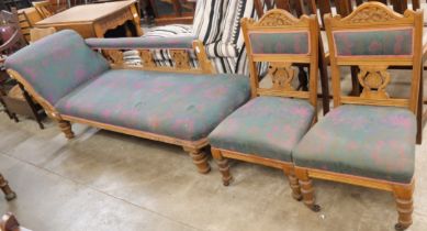 An oak and upholstered chaise longue