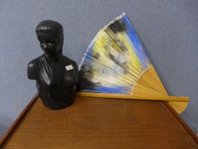 A black porcelain bust of a lady and a large oriental fan