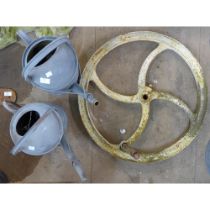 A cast iron wheel crank and two galvanised watering cans