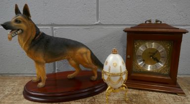 A Metamec wooden cased clock, a model of a German Shepherd and a decorative egg **PLEASE NOTE THIS