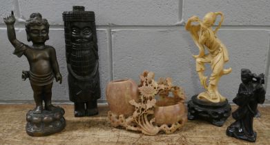 A soapstone carving, an African carved wooden figure, a bronze Tibetan figure and two other figures
