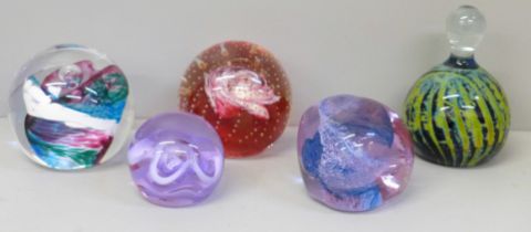 A collection of four Caithness and one Mdina glass paperweights