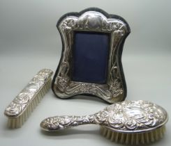 Two silver backed brushes and a silver photograph frame