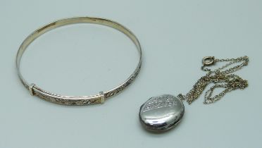 A silver bangle and a 'silver back & front' locket with chain