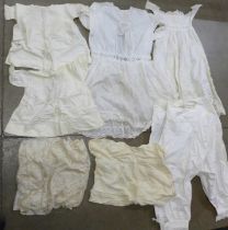 A collection of lace items including christening gowns and other early 20th Century clothing