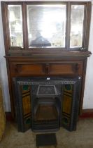 An Edward VII walnut chimney-piece with tiled back cast iron fire surround