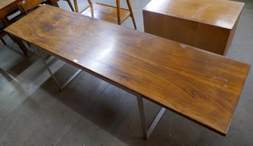 A long chrome and walnut dining table