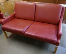 A Danish Thams crimson leather two seater sofa, designed by Rud Thygesen