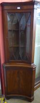 A Regency style mahogany freestanding concave corner cabinet