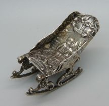 A Dutch embossed miniature silver rocking chair with courting couple