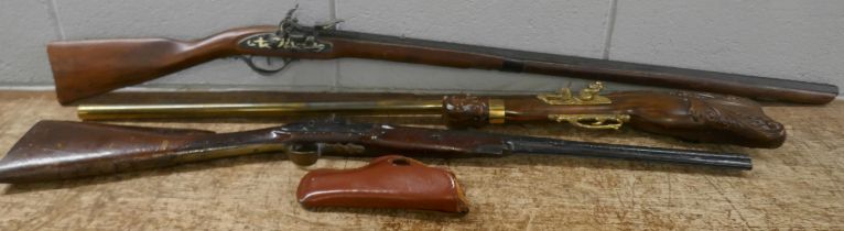 An ornate composite rifle, a flintlock rifle with brass butt, holster and one other replica