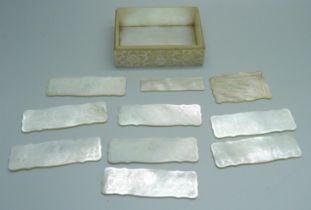 A collection of mother of pearl gaming counters in a mother of pearl box, lacking lid