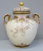 A Royal Worcester scroll handled vase and cover, decorated and gilt with blossom on a shaded ivory