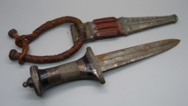 A North African white metal dagger with leather and white metal scabbard