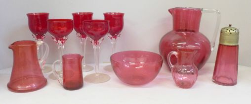 Five cranberry glass wines, four cranberry glass jugs (one large), a castor and bowl **PLEASE NOTE