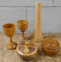 Treen comprising of two hardwood lidded pots, two goblets and a candle holder