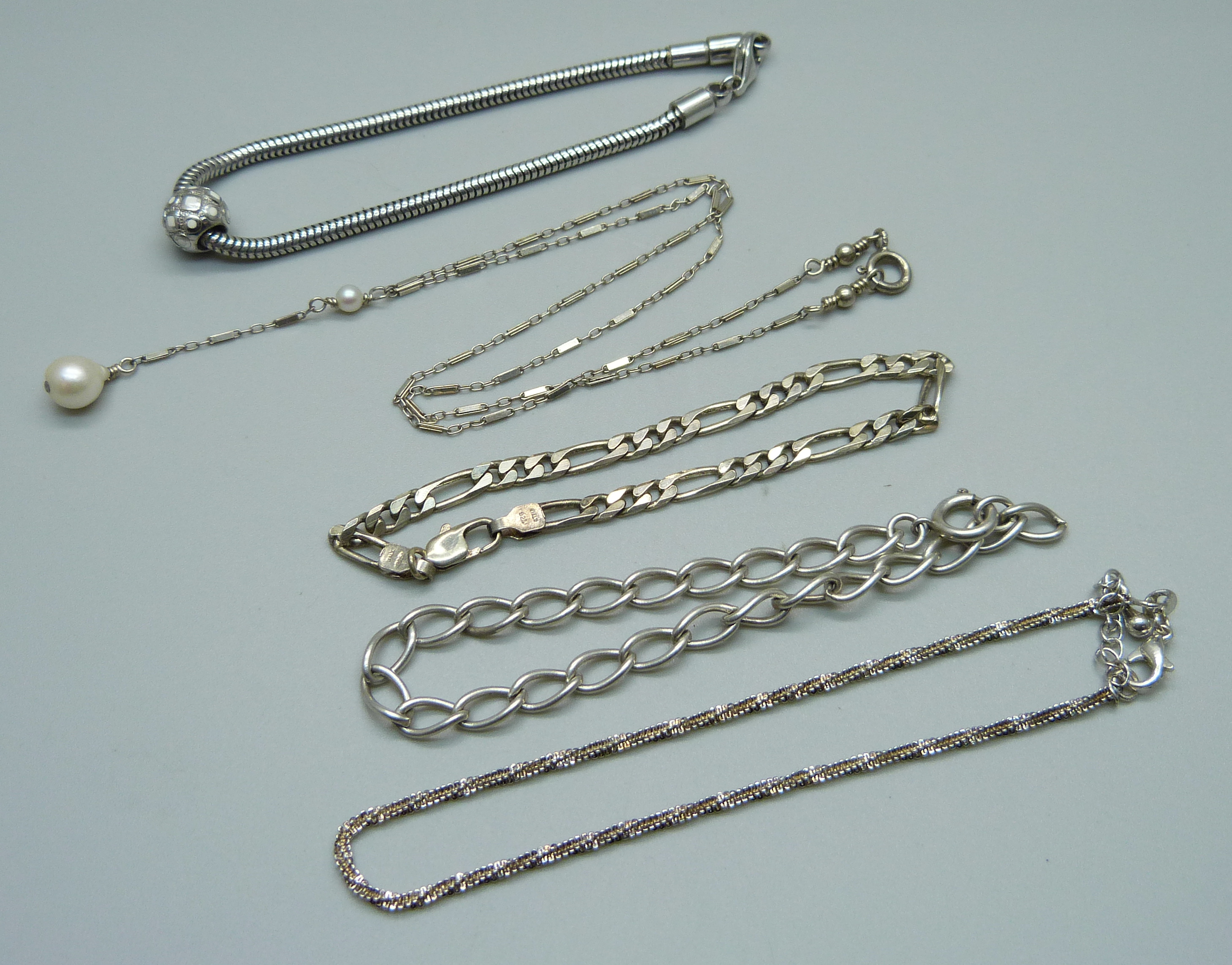 A silver necklace and four silver bracelets