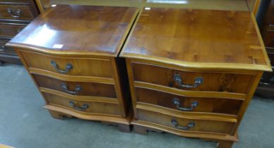 A pair of George III style yew wood serpentine chests of drawers