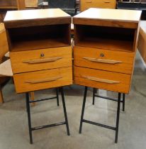 A pair of teak cabinets and black tubulor metal stands