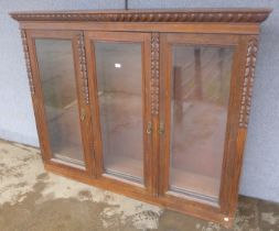 A late Victorian carved oak three door bookcase