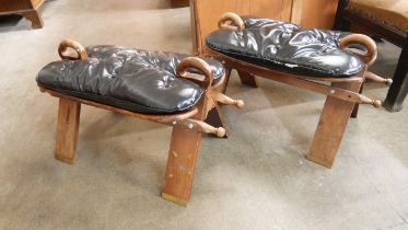 A pair of beech and black leather camel stools
