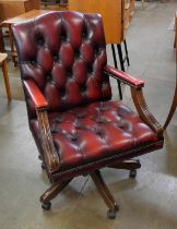 A mahogany and oxblood red leather revolving desk Captains chair