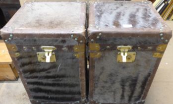 A pair of hide covered and brass mounted trunks