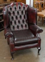 An oxblood red leather Chesterfield wingback armchair