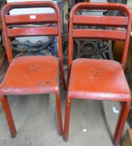 A set of four red industrial chairs