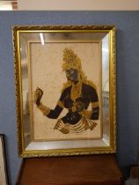 An oriental print of a deity, framed