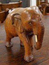 An African carved wooden elephant with faux ivory tusks