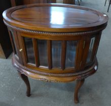 An oval carved hardwood drinks cabinet