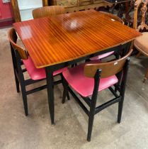 A Harris Lebus tola wood and black extending dining table and four chairs
