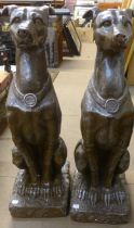 A pair of faux bronze garden figures of seated hounds