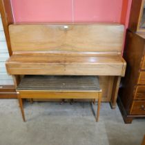 A teak upright piano with faux ivory keys and a piano stool