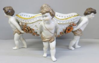 A continental porcelain hand painted four cherub centrepiece, 34cm