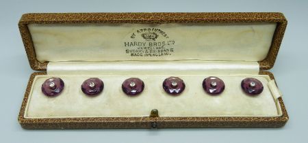 A cased set of six amethyst coloured buttons