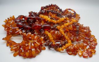A collection of nine amber necklaces and a pendant