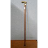 A brass wall clock and a walking cane
