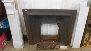 A Victorian style cast iron fire surround with marble chimney-piece