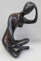 An abstract bronzed figure of a seated lady