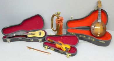 Four miniature instruments, two classical guitars, a violin and a bugle