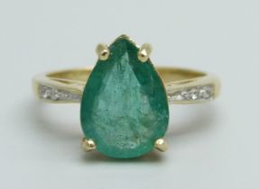 A 9ct gold and pear shaped emerald ring with diamond shoulders, emerald approximately 11 x 8 x