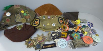 A collection of badges, patches and hats including some military related