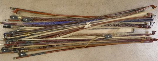 A collection of violin and cello bows, one marked Penzel and one marked Japan