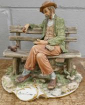 A Neopolitan figure of a tramp on bench feeding a squirrel, signed Buon Cuore