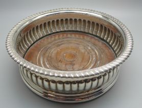 A silver wine coaster with wooden base, London 1816, 17cm diameter