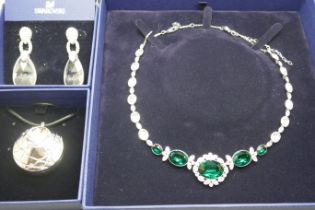 Swarovski jewellery; a pair of earrings, a necklace and a face and body highlighter pendant, all