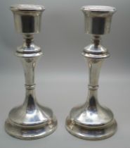 A pair of silver candlestick holders with weighted bases, 18cm