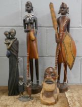 A carved hardwood tribal figure head, a pair of hardwood tribal figures with beaded decorations,